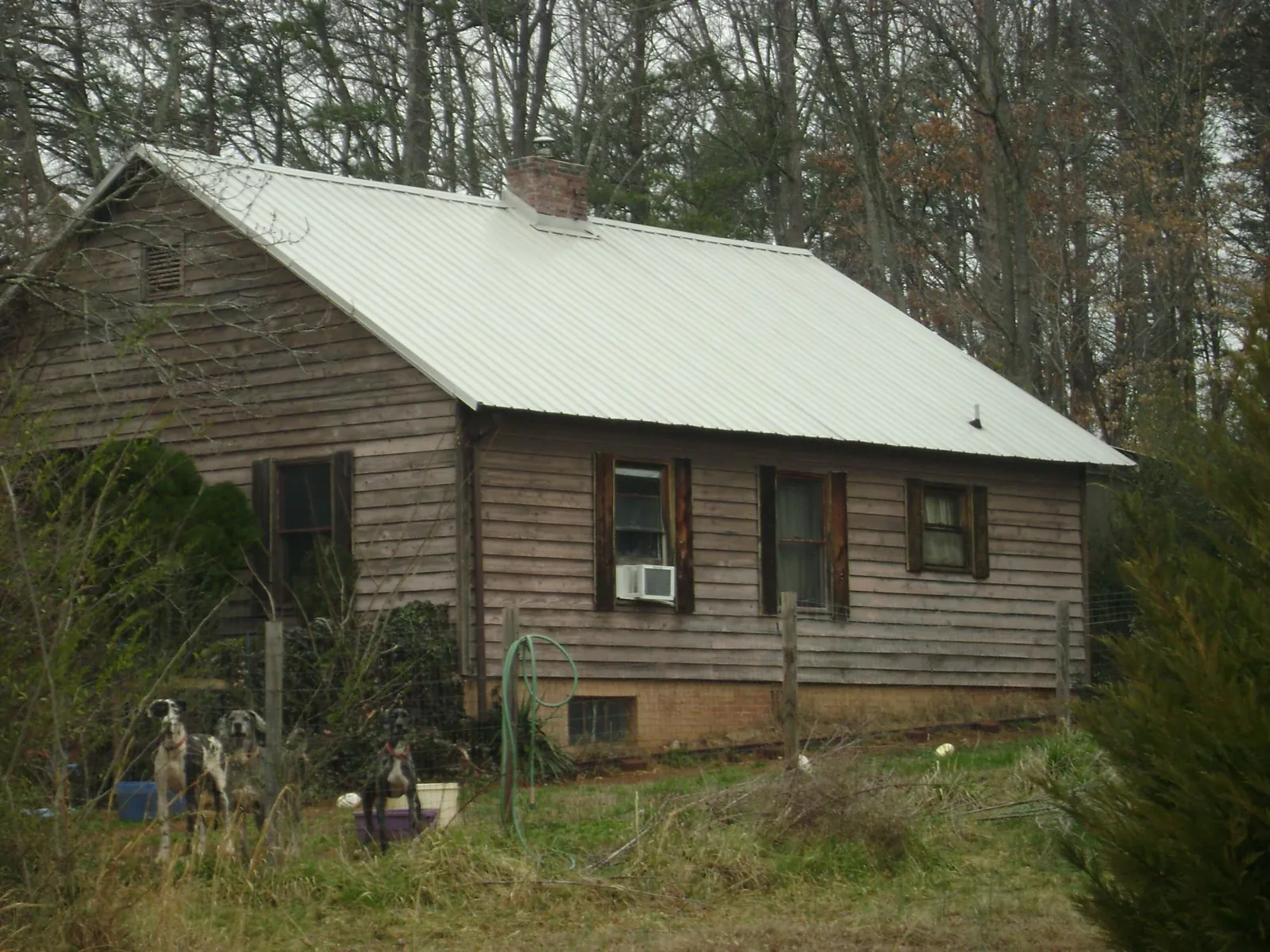 White metal roof on an old wood sided farmhouse, from a Metal Roof Installation job in Oneida